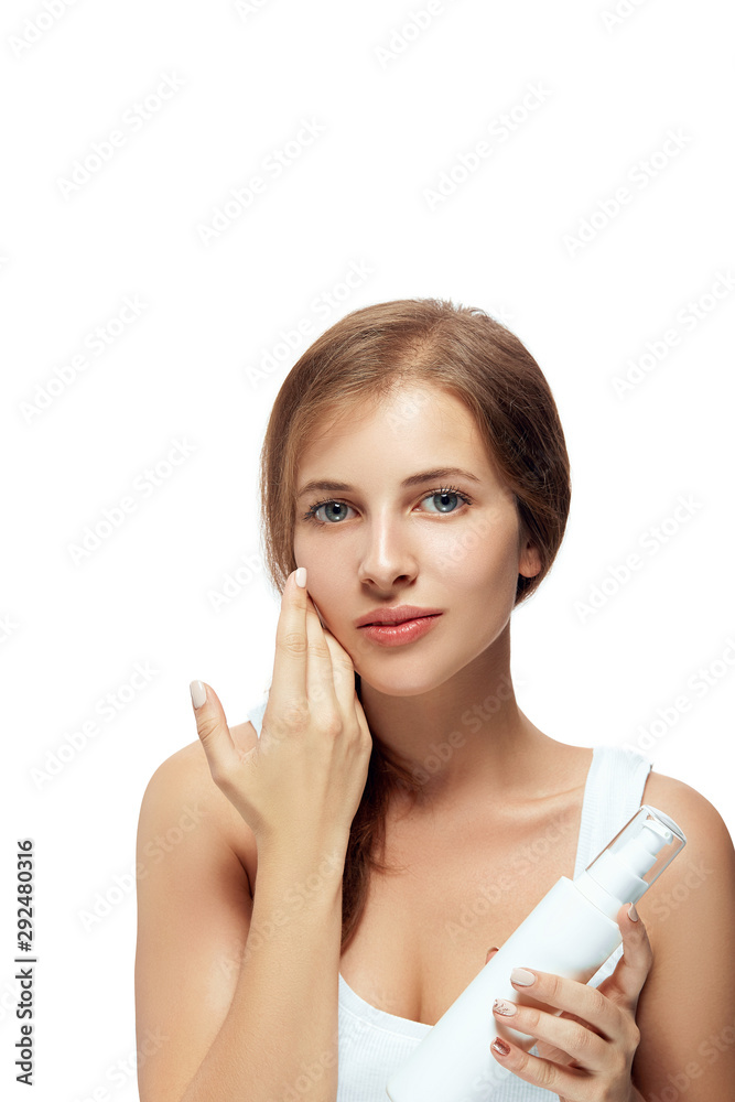 Skin care. Beauty Concept. Young woman holding cosmetic moisturizing cream. Soft skin, model with light nude make-up, portrait of girl face with clean healthy skin. Dermatology