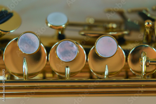 The saxophone pipe valves on the defocused background. Musical instrument photography.