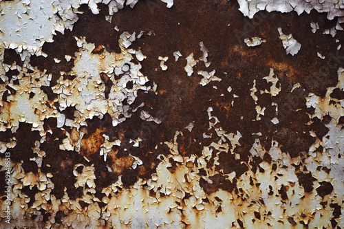 Old weathered rusty metal surface with white paint peeling off. Grunge background photo