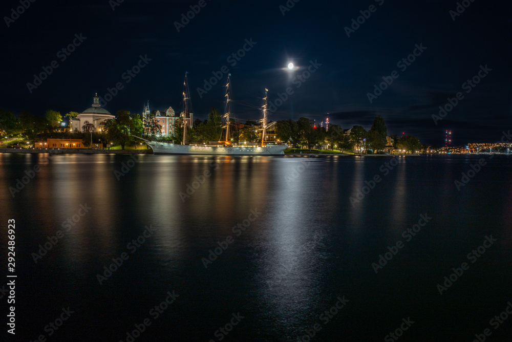 A white sailing boat moored in the night in Stockholm