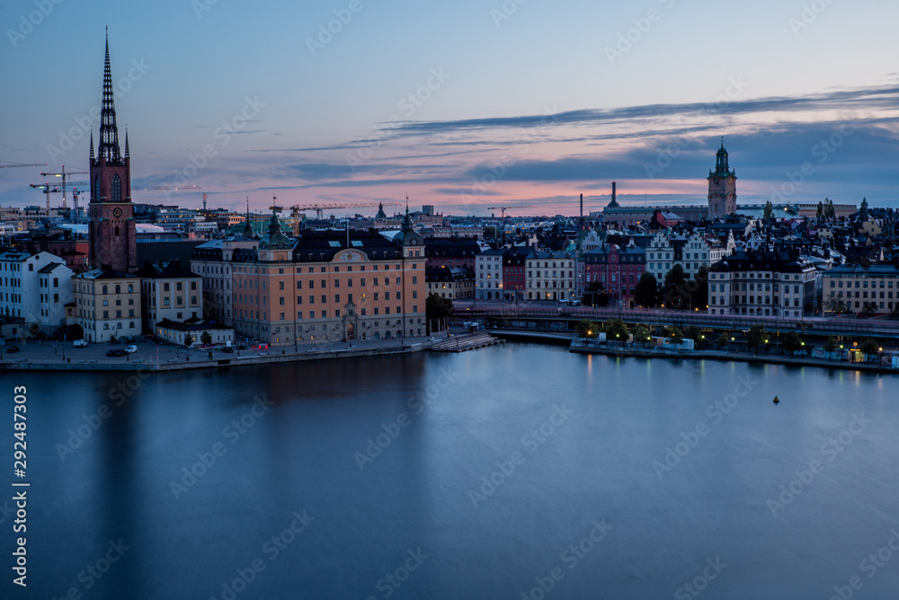 A colorful sunrise over Stockholm with the lights reflecting on the calm water of the sea - 6