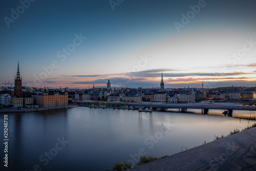 A colorful sunrise over Stockholm with the lights reflecting on the calm water of the sea - 7 © gdefilip