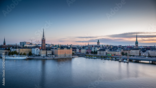 A colorful sunrise over Stockholm with the lights reflecting on the calm water of the sea - 8
