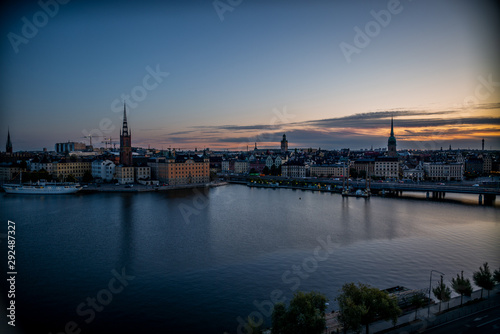 A colorful sunrise over Stockholm with the lights reflecting on the calm water of the sea - 9 © gdefilip