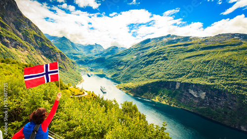 Tourist over Geirangerfjord with norwegian flag photo