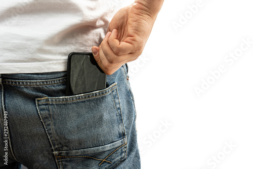 A man pulls a smartphone out of the back pocket of his jeans