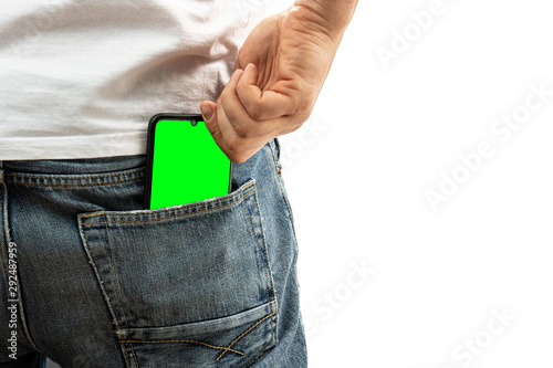 A man pulls a smartphone out of the back pocket of his jeans photo