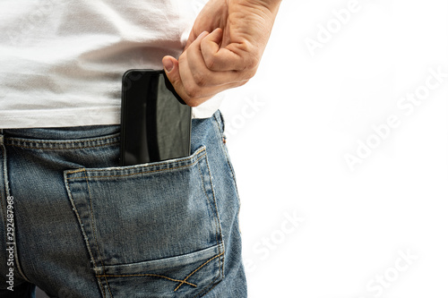 A man pulls a smartphone out of the back pocket of his jeans
