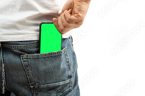 A man pulls a smartphone out of the back pocket of his jeans photo
