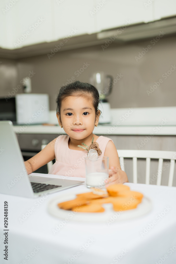 Happy Asian family are eating breakfast and see digital tablet in the kitchen at home. Healthy food and Morning activities