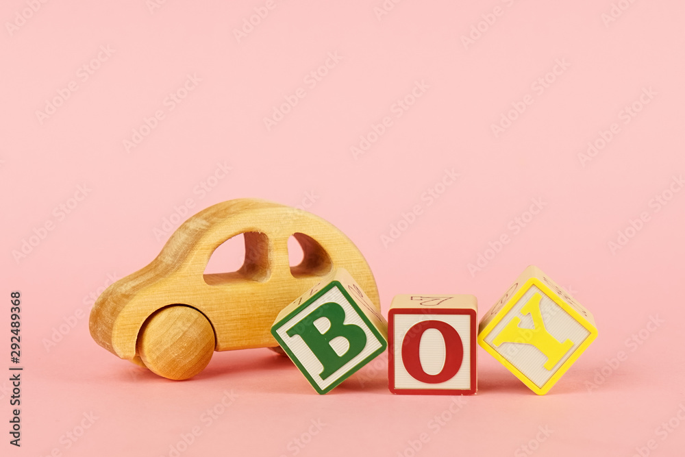 Colored cubes with letters Boy and toy on a pink background