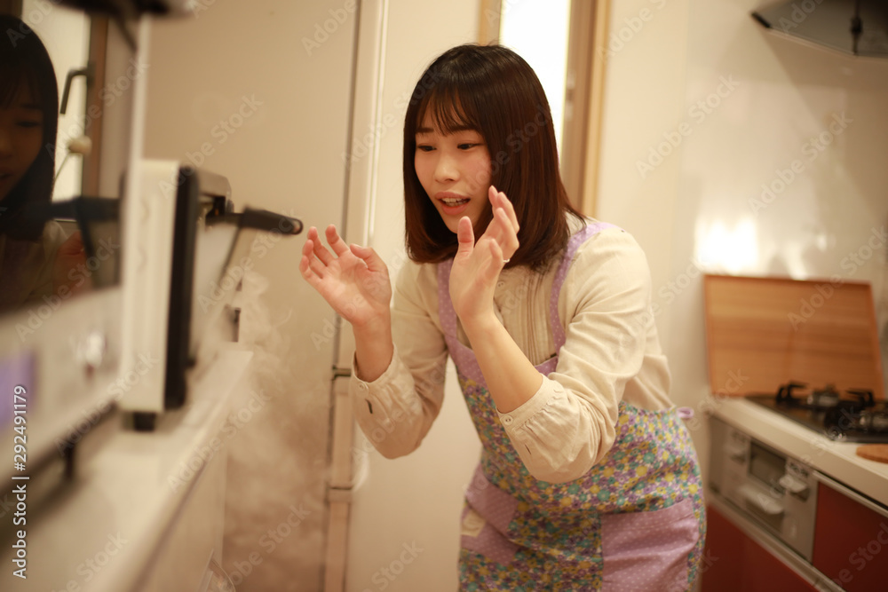 オーブントースターが故障し慌てる女性 オーブントースターが故障し慌てる女性