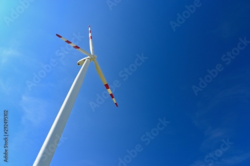 Wind turbine - windmill with blue sky background. © montypeter