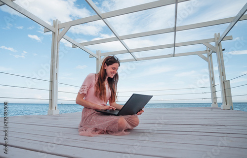 girl with laptop on the beach