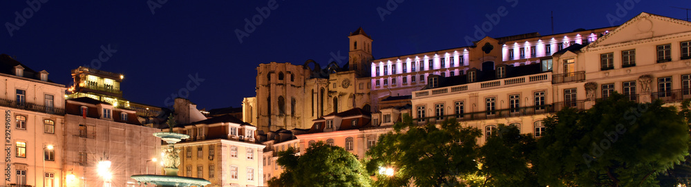 night view of bronze fountains and illuminated buildings at Praca Dom Pedro IV, Rossio square in Lisbon, Portugal
