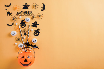 Top view of Halloween crafts, orange pumpkin, ghost, bat and spider on orange background with copy space for text. halloween concept.
