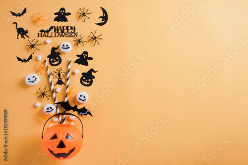 Top view of Halloween crafts, orange pumpkin, ghost, bat and spider on orange background with copy space for text. halloween concept.