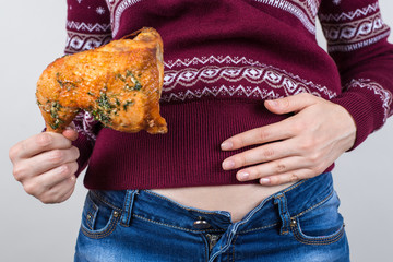 Junk food eating too much concept. Cropped close up photo of girl holding hands palm on big full abdomen feeling heartburn after fatty greasy nutrition isolated grey background