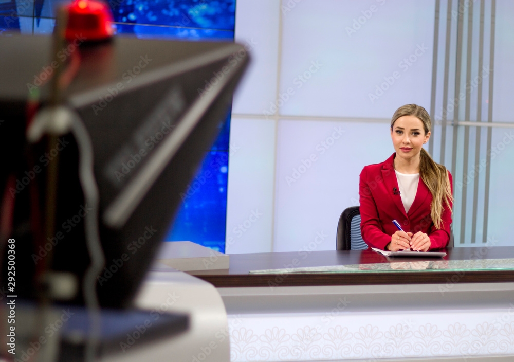 News anchor in the TV Studio . Beautiful girl reading the news, on a blue screen background - obrazy, fototapety, plakaty 