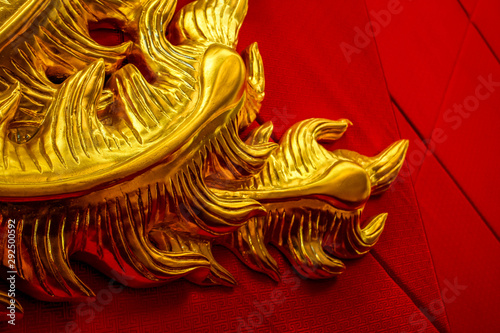 sculpture chinoise en or sur un mur rouge en velours