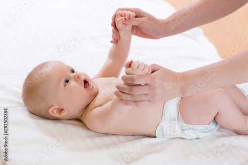 Baby massage. Massagist massaging and doing gymnastic to little kid