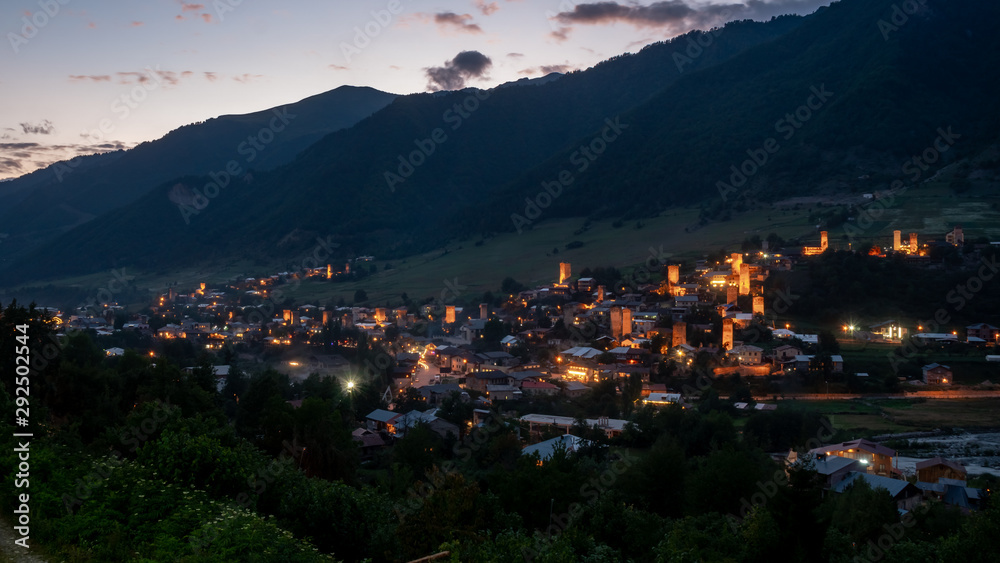 Night view on Mestia with its beautiful illuminated Svan Towers and high mountains. Svaneti, Georgia.