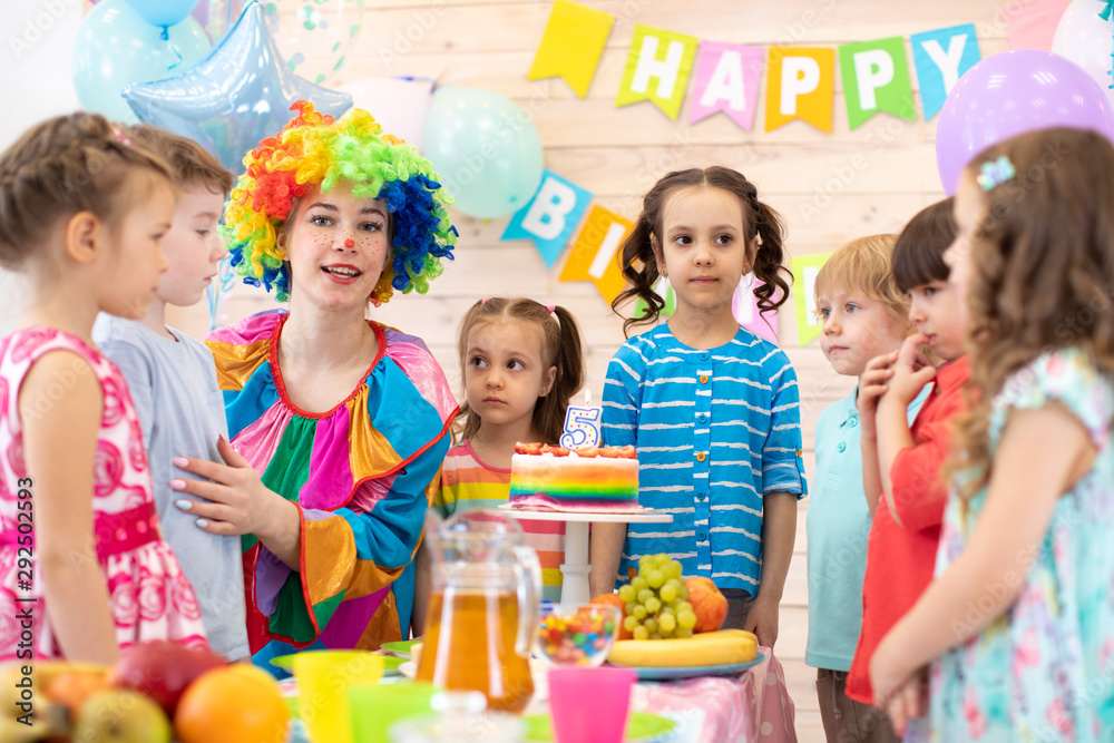 Fototapeta premium kids celebrating birthday party with clown
