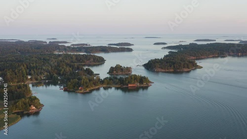 Aerial, tracking, drone shot, overlooking small islands in the Espoo archipelago, at dusk, on a sunny, autumn evening, in Soukka, Uusimaa, Finland
 photo