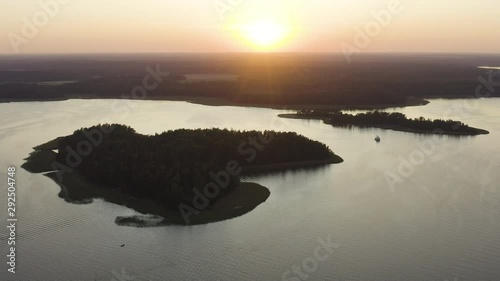 Aerial, drone shot, panning around a island, overlooking a boat, anchored between small islands in the Espoo archipelago, at sunset, on a sunny, autumn evening, in Soukka, Uusimaa, Finland
 photo