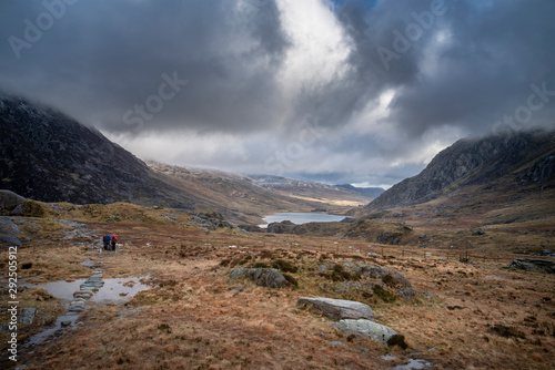 Hikers in Ogwen Valley Winter landscape with snowcapped Pen Yr Ole Wen and Tryfan mountains