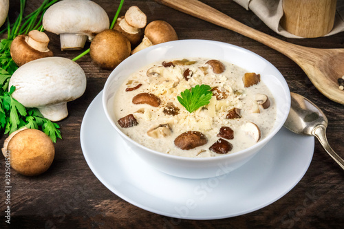 Mushroom soup with ingredients on a dark rustic wooden background