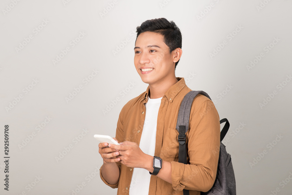 Young Asian Student Texting on Cell Phone Isolated on White Background Young Asian Student Texting on Cell Phone Isolated on White Background