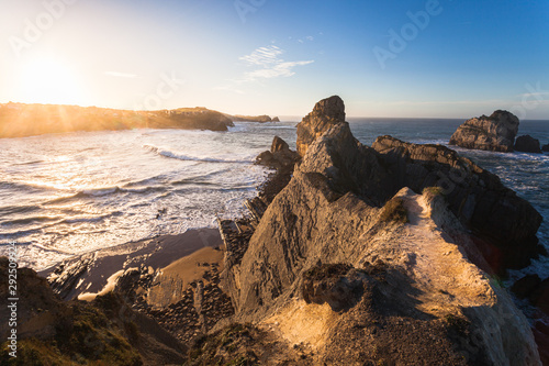 Sunset view from los urros at spain, north atlantic coastline. Backlight sunlight lighting the ocean and harsh cliffs. hiking person enjoying the wide magic view.