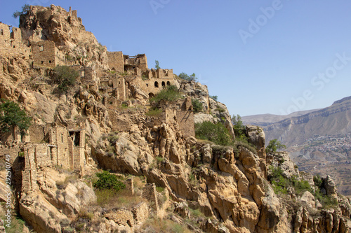 City - ghost, Dagestan, Russian - 1 SEPTEMBER, 2019: City of ancient ruins, city - ghost, mountainous area with green vegetation on background rocks, of blue sky and green forest