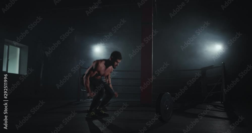 Attractive athletic guy doing hard workout in the cross fitness very strong guy practicing cross fitness exercises