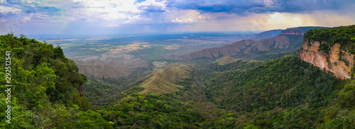 Panoramic view from top of cliffs in an opening valley in the late afternoon with clouds and sunrays, Chapada dos Guimarães, Mato Grosso, Brazil, South America