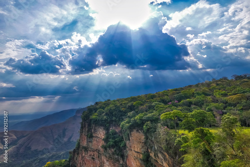 Panoramic view from top of cliffs in an opening valley in the late afternoon with clouds and sunrays, Chapada dos Guimarães, Mato Grosso, Brazil, South America