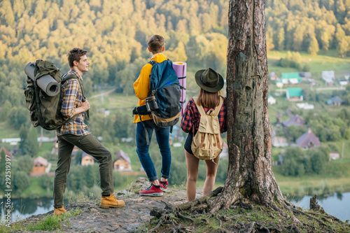 three tourists aking decission where to gom expedition, back view photo