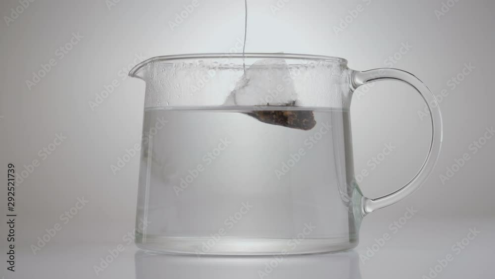 Close-up demonstration video of a tea pack soaking in glass pot. Fruit tea making. Close-up demonstration video of a tea pack soaking in glass pot. Fruit tea making.