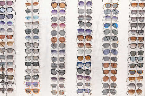 many different sunglasses on display shelves in store, business, helath eyes care. sale, discount photo