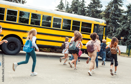 Photo Classmates running to school bus back view late