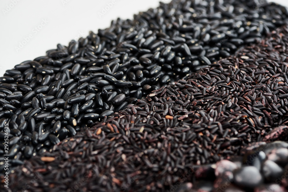 raw wild rice near black beans isolated on white raw wild rice near black beans isolated on white