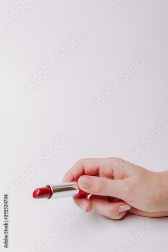 Red lipstick held in female hand  copyspace