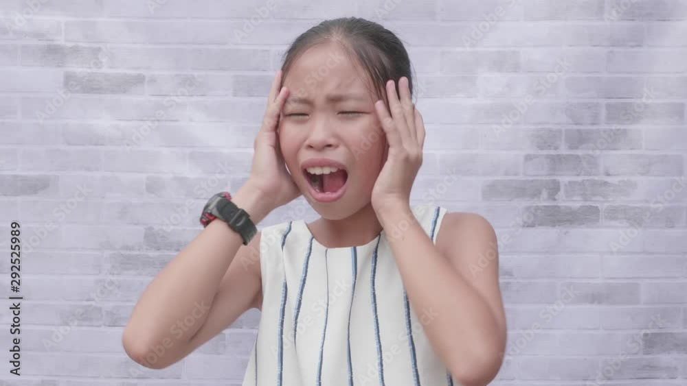 Child shouting loud. Stylish asian girl holding hands near head. Portrait of shocked, angry and emotional asian girl. Child shouting loud. Stylish asian girl holding hands near head. Portrait of shocked, angry and emotional asian girl.