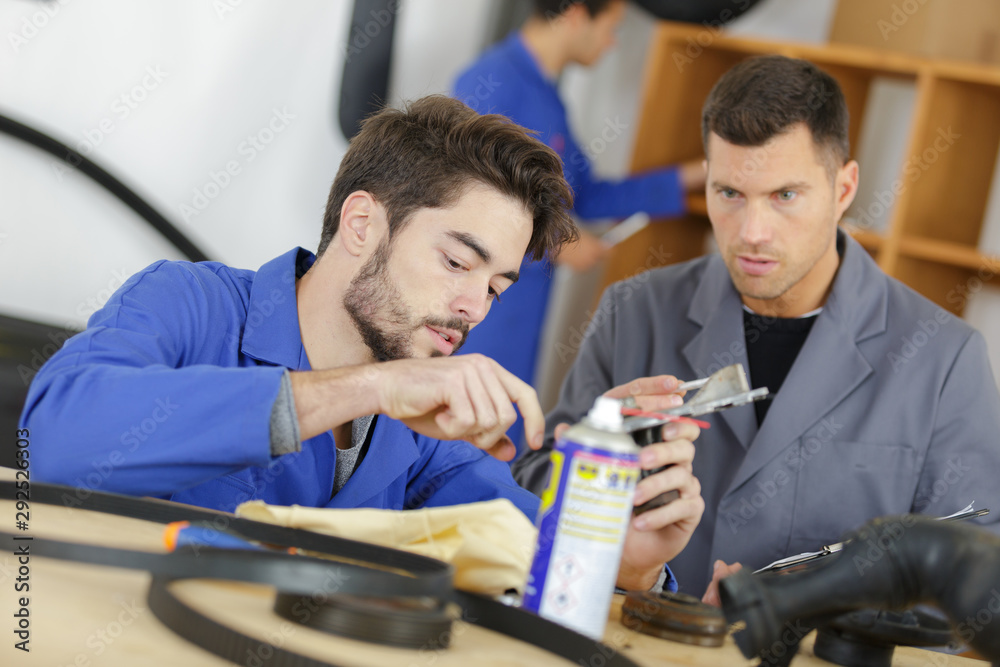 young mechanical apprentice with engine parts