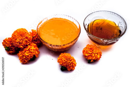 Marigold flower face mask isolated on white in a glass bowl consisting of marigold flower and honey well mixed. With all constituents. photo