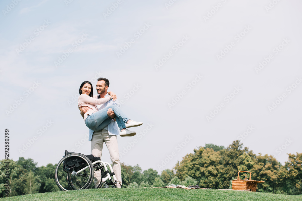 cheerful young man holding on hands happy disabled girlfriend cheerful young man holding on hands happy disabled girlfriend