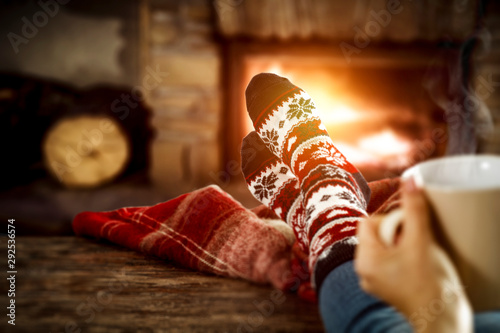 Fireplace and slim woman legs with christmas socks 