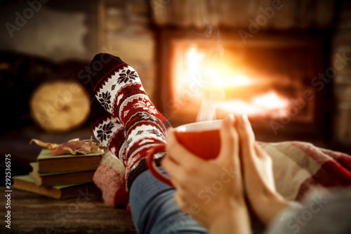 Fireplace and slim woman legs with christmas socks 