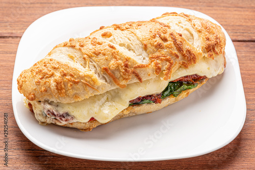 Beef steak sandwich with cheese and tomato, isolated on wooden background